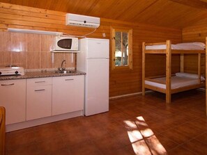 A compact wooden cabin with a kitchenette, a single bed, and a window. - Bungalow with AC, pets allowed - 8 guests (Marbella)
