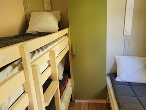 A bunk bed room with a green wall and a single bed with a white pillow. - Chalet with air conditioning and pets allowed - 5 guests (Pamiers)