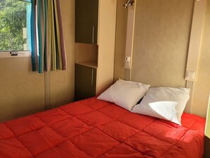 A room with a bed, a wardrobe, and a window with curtains. - Chalet with air conditioning and pets allowed - 5 guests (Pamiers)
