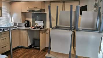 Una cucina compatta con piano cottura integrato, macchina da caffè e tostapane.