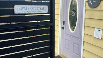 A gated entrance with a sign indicating it is a private courtyard for cottage guests only.