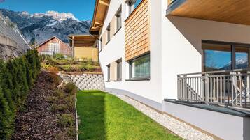 Ein modernes Gebäude mit geneigtem Dach, großen Fenstern und einem Balkon.