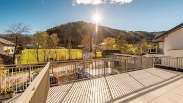 A balcony with a view of a mountain and a clear sky.