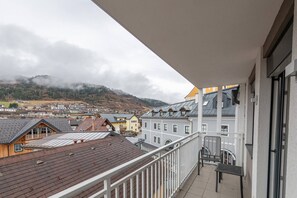 Un balcon avec vue sur la ville et les montagnes.