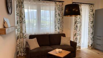 Un salon avec un canapé, une table basse et une lampe.