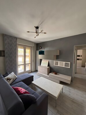 Una sala de estar moderna con sofá, mesa de centro y estanterías empotradas.