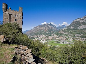 A historic stone castle with a view of a town and mountains in the background. - Apartment 'Soleil Lou' with Mountain View and Balcony (Châtillon)