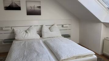 Ein Schlafzimmer mit einem Bett, zwei Kissen, einem Kopfteil und einem Oberlicht.