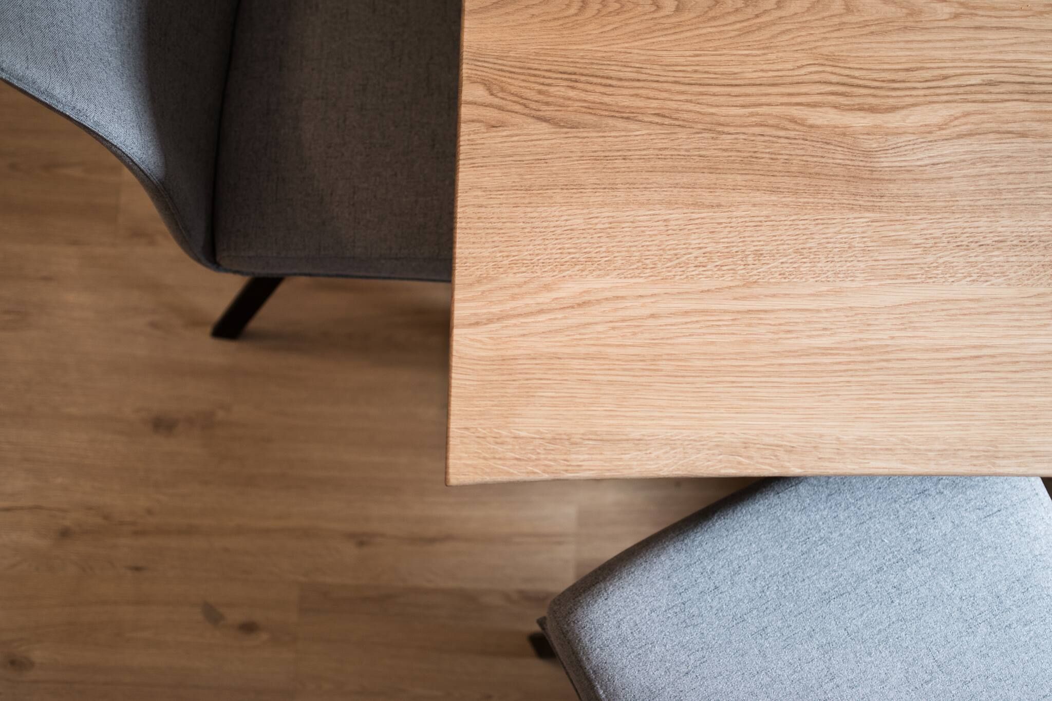 Une table en bois avec une chaise dont l’assise est recouverte d’un tissu gris.
