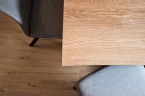 Ein Holztisch mit einem grau gepolsterten Stuhl.