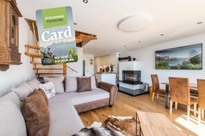 Un salon moderne avec un canapé, des meubles en bois, une cheminée et un tableau représentant un paysage.