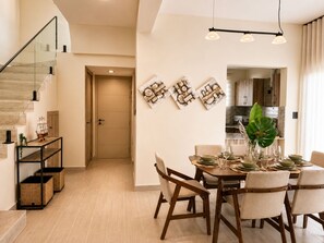 Un interno moderno con zona pranzo, scale e cucina.