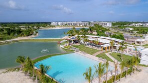 Un resort con una grande piscina, una spiaggia e vista sull'oceano.