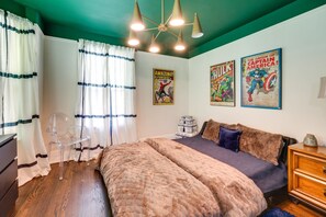 A bedroom with a bed, a chair, a dresser, and a poster on the wall. - Upscale Boutique Home in Midtown Detroit (Detroit)