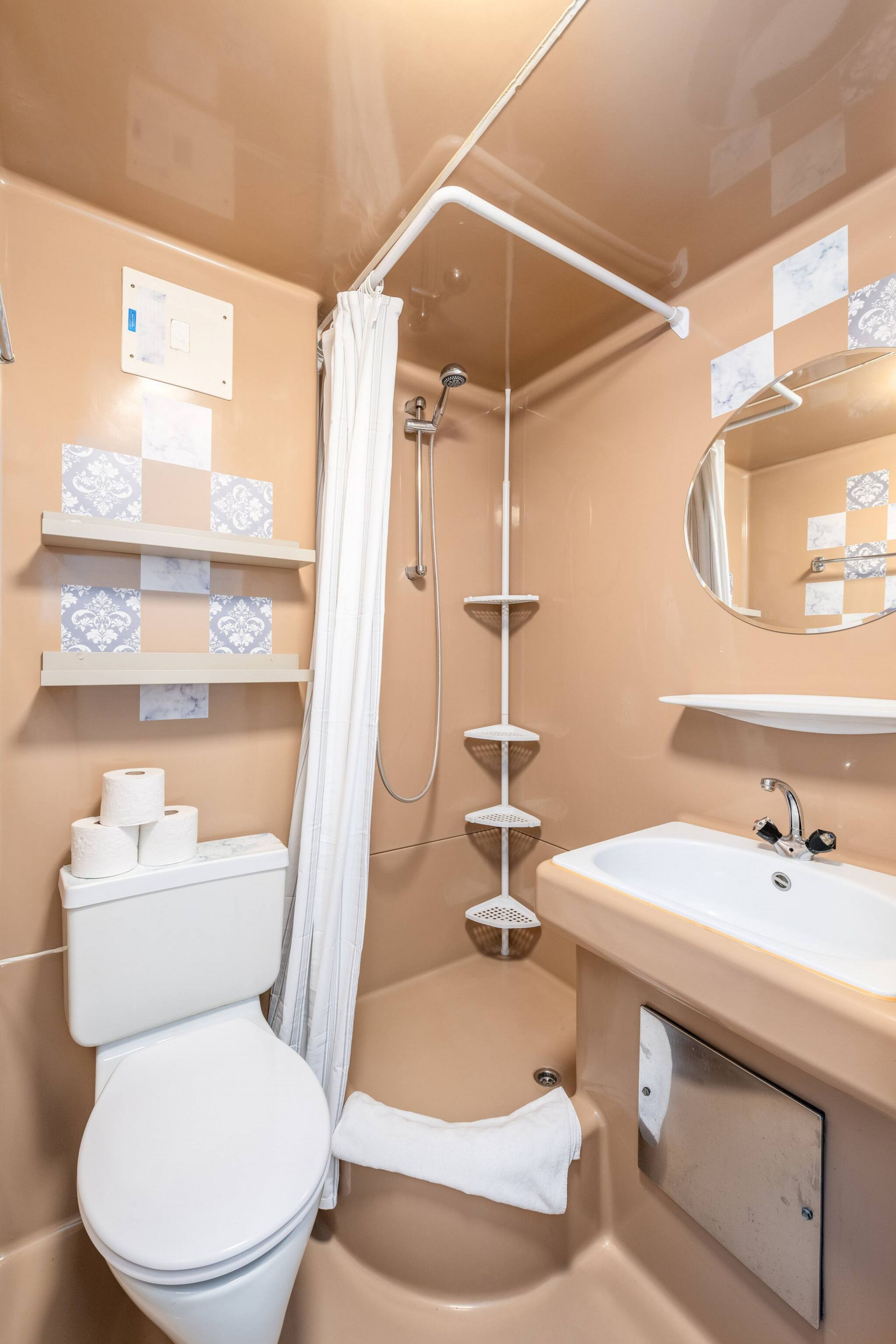 Un bagno con il water, una doccia, un lavandino e uno specchio.