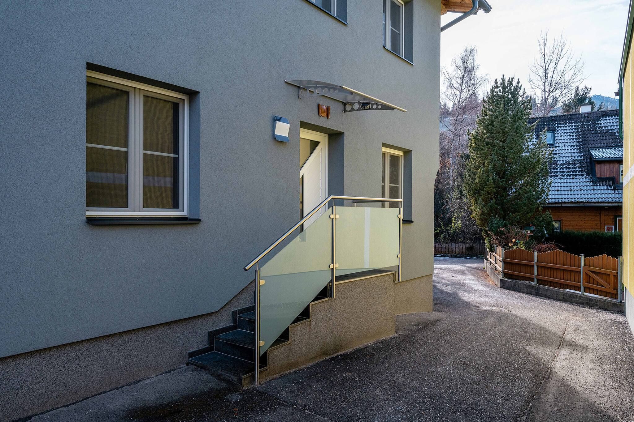 Ein Gebäude mit einer Treppe, die zu einer Tür, einem Fenster und einem Briefkasten führt.