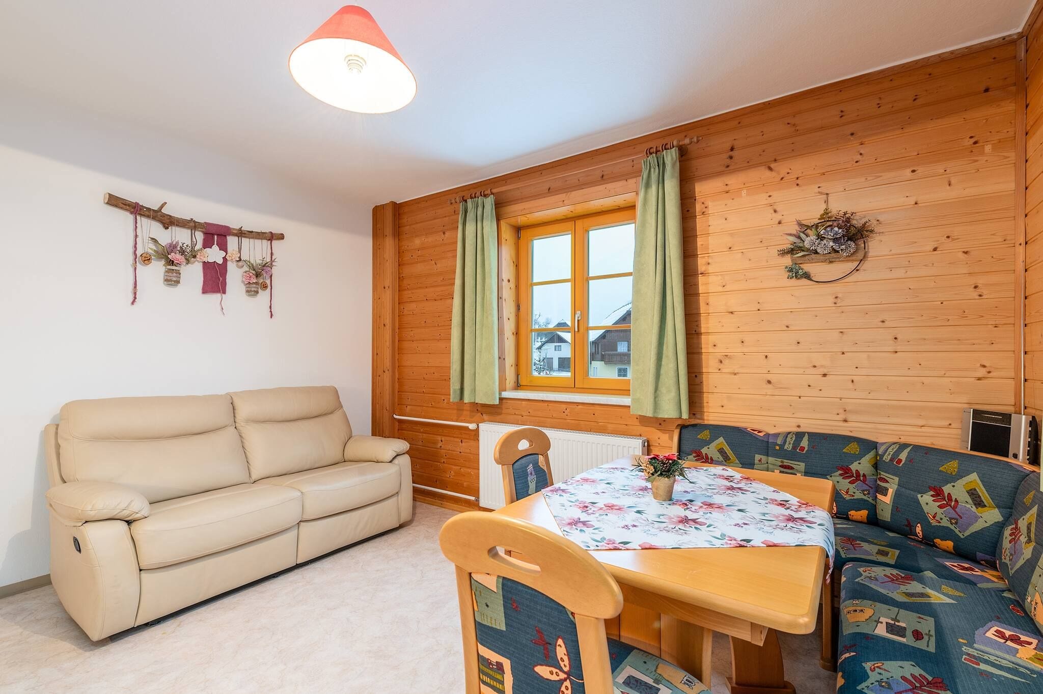 A cozy room with a sofa, a table, and a window with curtains.