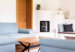 Ein modernes Wohnzimmer mit einer Couch, einem Couchtisch und einem Kamin.