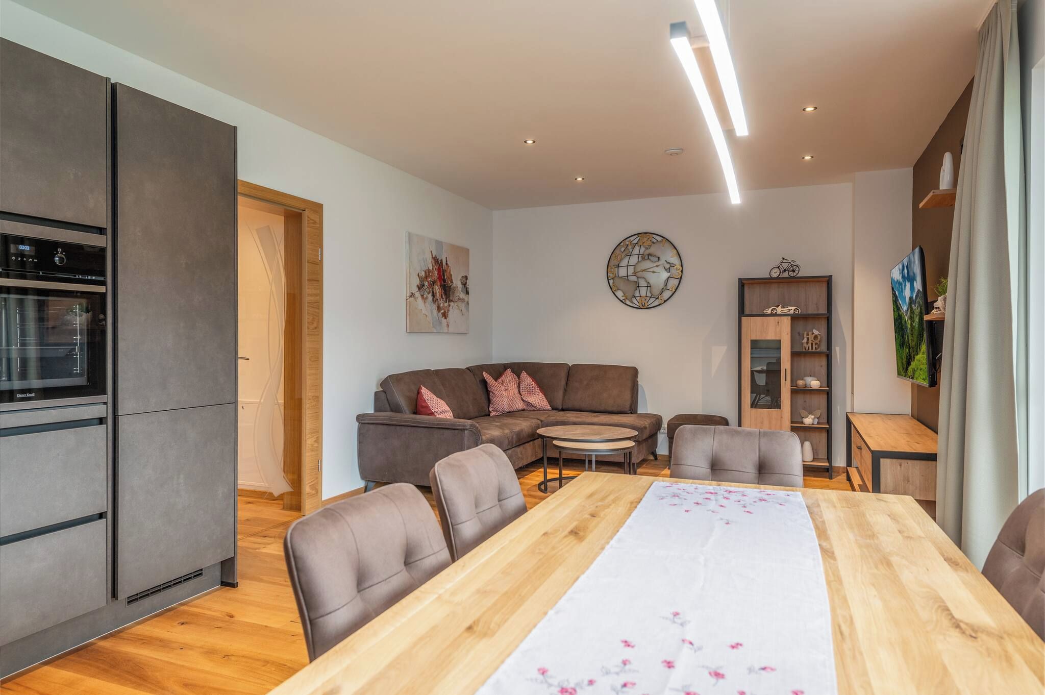 A modern living space with a kitchen, dining area, and seating.