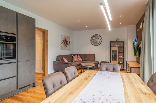A modern living space with a kitchen, dining area, and seating. - GardenAlpin Apartment (Aich-Assach)