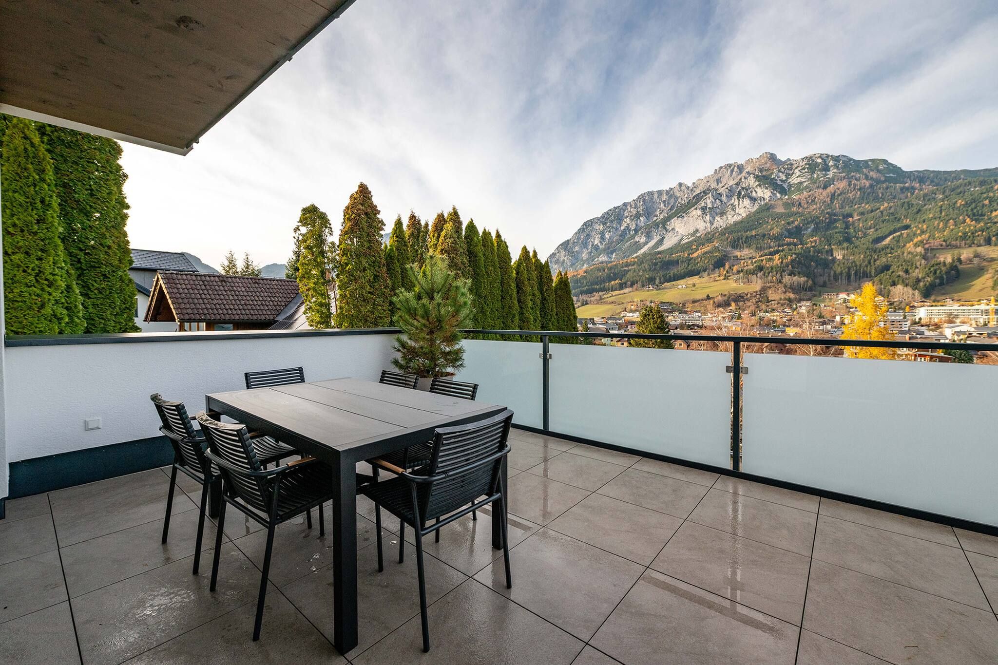 Une terrasse avec une table et des chaises, donnant sur un paysage montagneux.