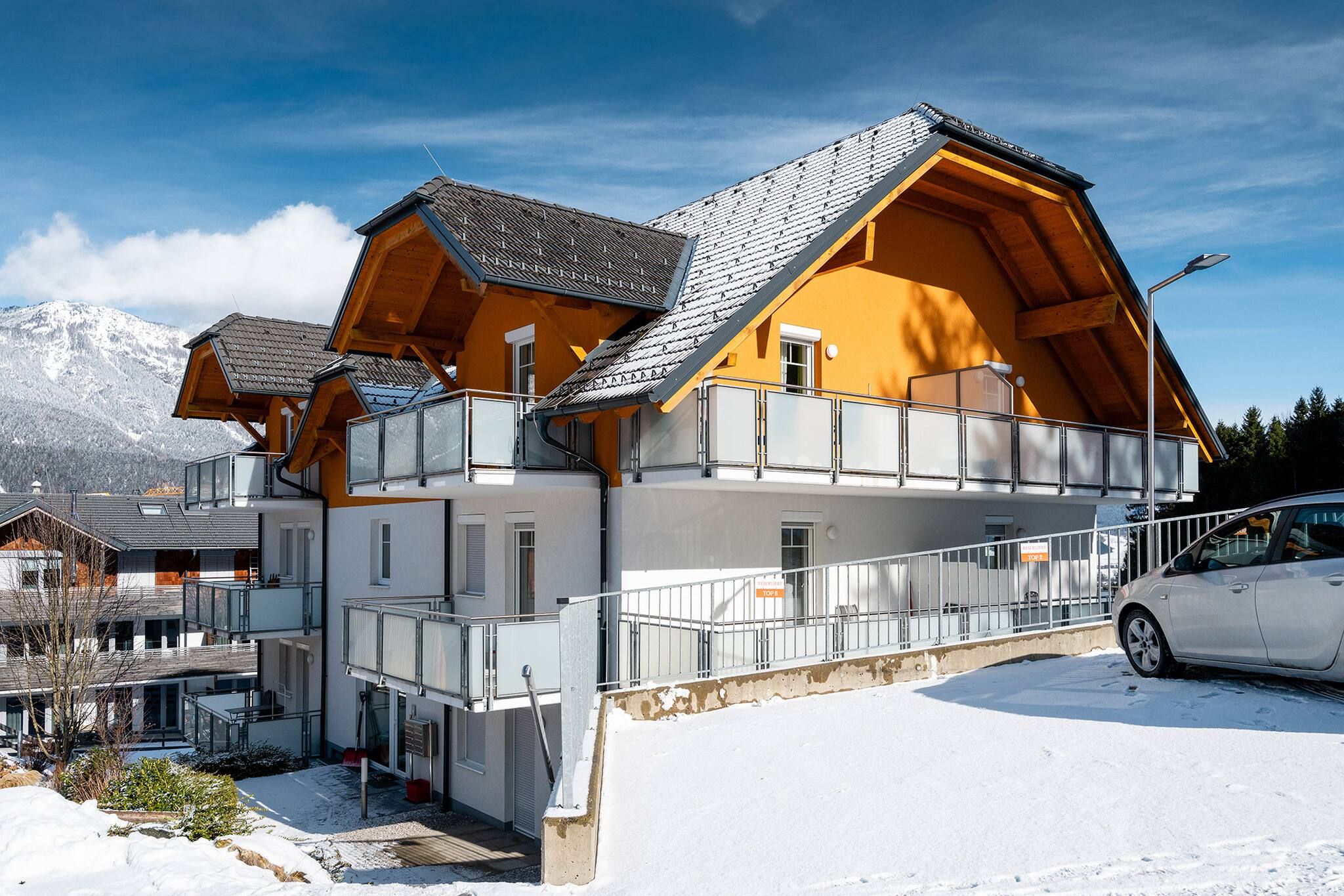 Ein mehrstöckiges Chalet mit Skilift, schneebedeckter Umgebung und Bergkulisse.