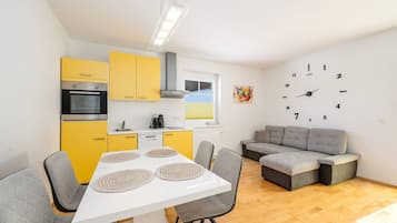 Ein kompakter Wohnraum mit Küche, Essbereich und Sitzgelegenheiten.