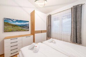 A hotel room with a bed, a dresser, a painting, and a window with curtains. - PanoramaAlpin Apartment (Aich-Assach)