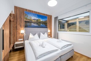 Ein Hotelzimmer mit einem Bett, einem großen Fenster und einer Holzvertäfelung.