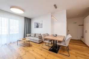 Ein modernes Wohnzimmer mit einer Couch, einem Esstisch und einem Couchtisch.
