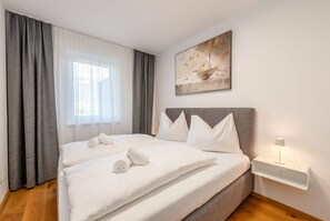 Ein Hotelzimmer mit Bett, Nachttisch, Lampe und einem Bild an der Wand.