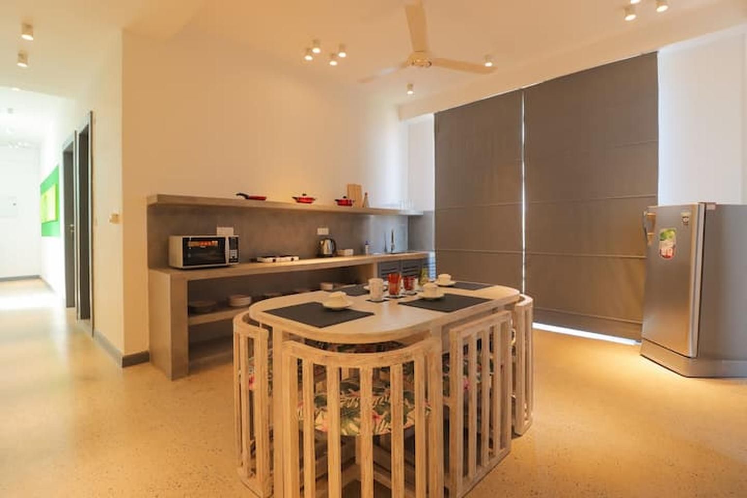 Una cocina moderna con una isla central, microondas integrado y refrigerador.