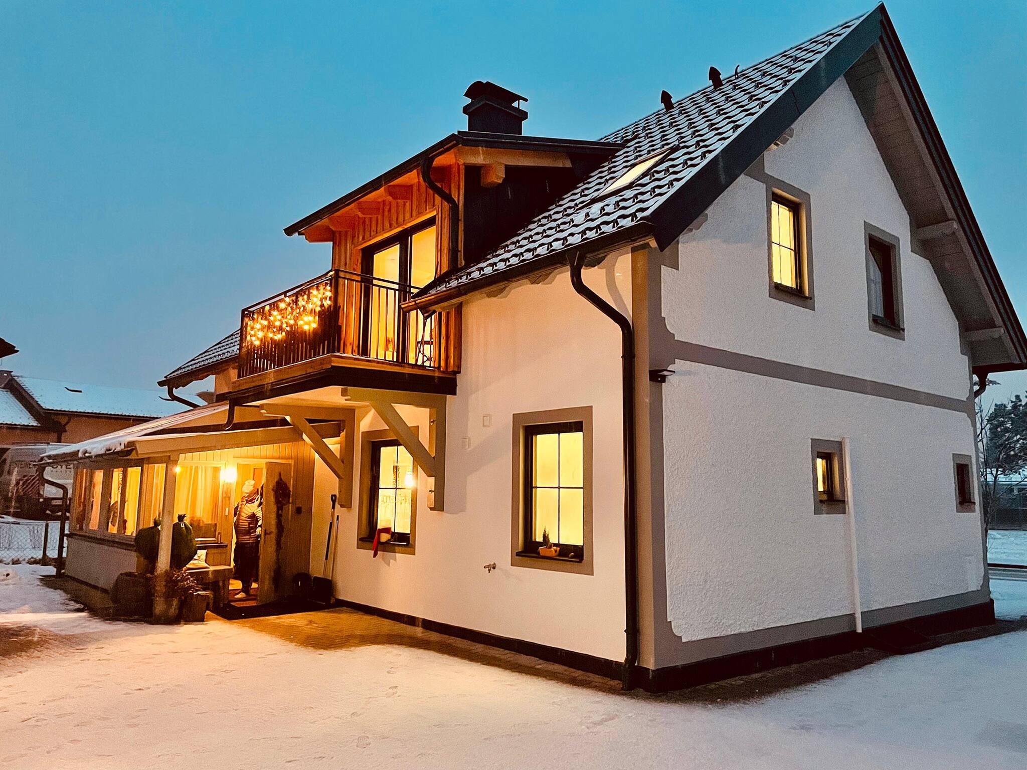 Een huis met twee verdiepingen, een balkon en een overdekte veranda.