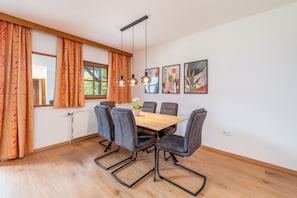 Un comedor con una mesa de madera, seis sillas y un radiador.