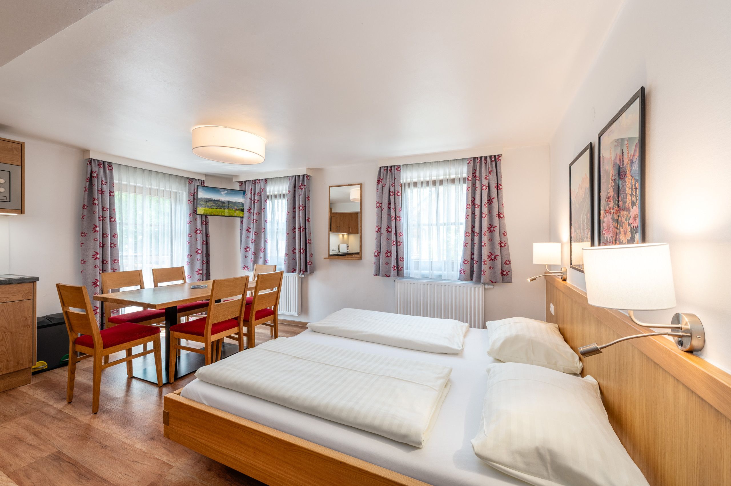 Una habitación de hotel con una cama, un escritorio, sillas y un televisor.