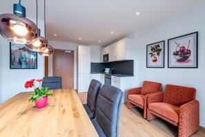 Un espacio de estar moderno con comedor, cocina y zona de descanso.