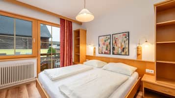 Habitación de hotel con una cama grande, una ventana con cortinas, un radiador y una obra de arte en la pared.
