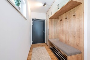 Ein Flur mit einer Bank, einer Tür und Holzschränken.