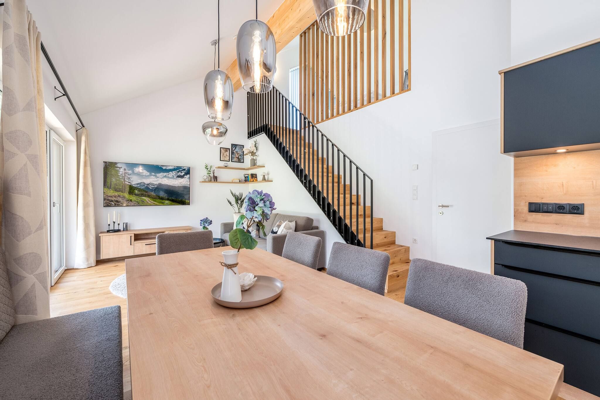 Ein modernes Interieur mit Essbereich, Treppe und Küche.