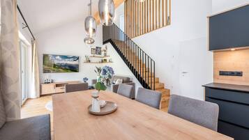 Ein modernes Interieur mit Essbereich, Treppe und Küche.
