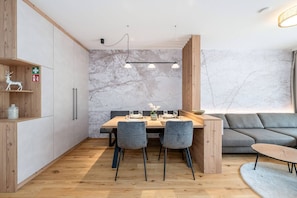 Eine moderne Küche mit einem Holzespeisetisch, grauen Stühlen und einer eingebauten Bank.