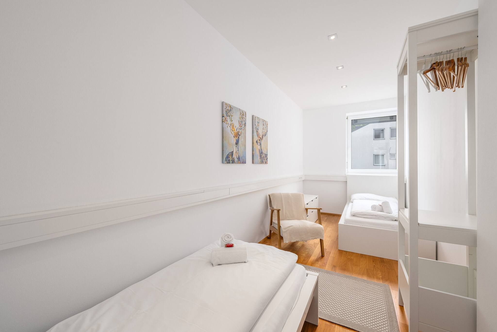 Ein Hotelzimmer mit einem Bett, einem Sessel, einem kleinen Tisch und Bildern an der Wand.