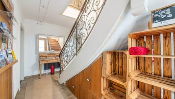 Eine Holztreppe mit Metallgeländer, ein Holztisch mit Spiegel und ein rotes Handtuch auf einer Holzablage.