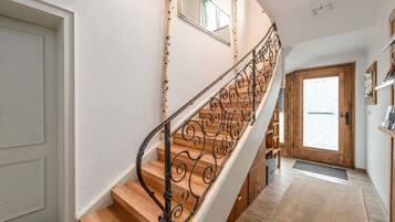 Eine Treppe mit aufwendiger Metallgeländer, die zu einer Holztür führt.