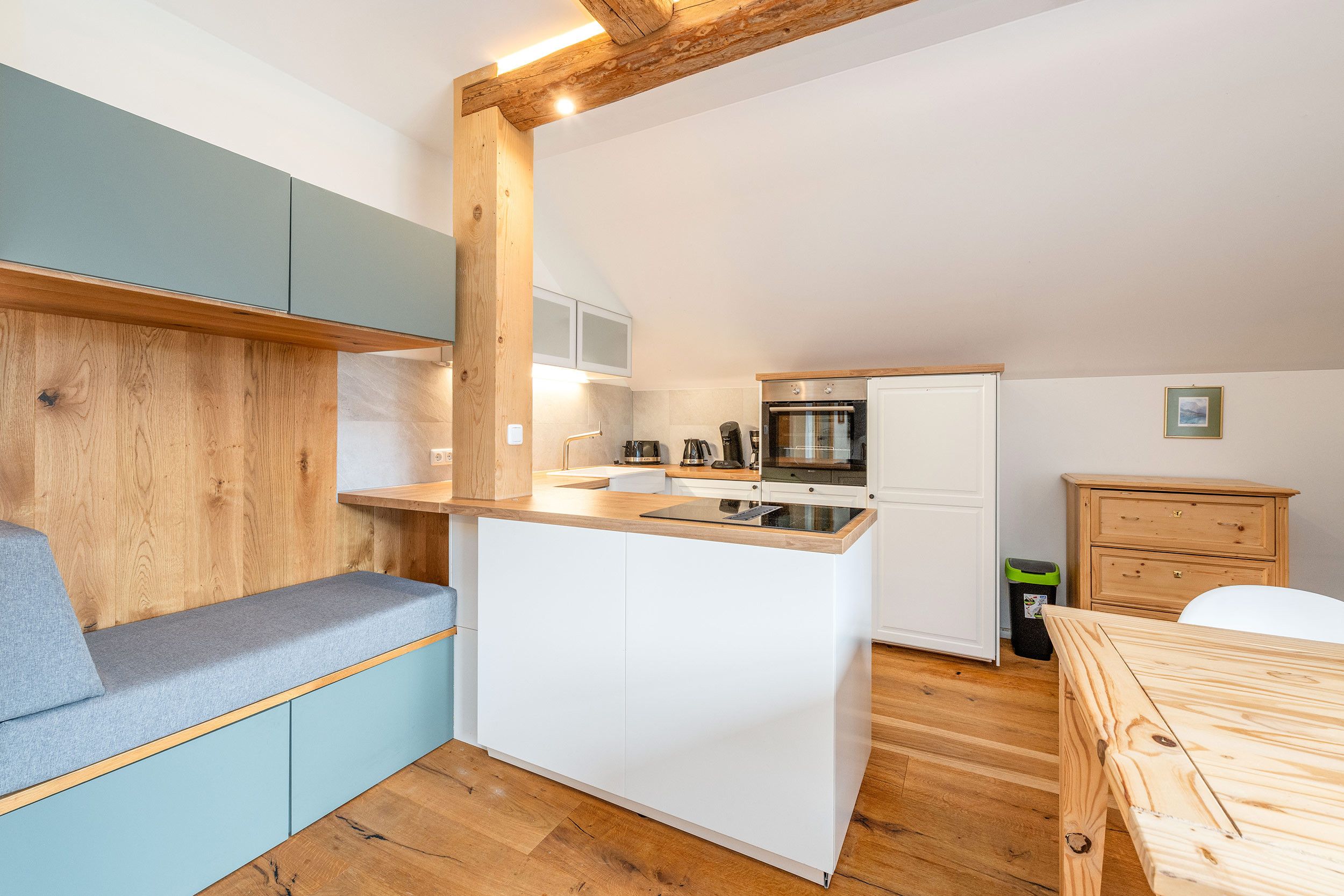 A compact kitchen with a built-in stove, a coffee machine, and a sink.
