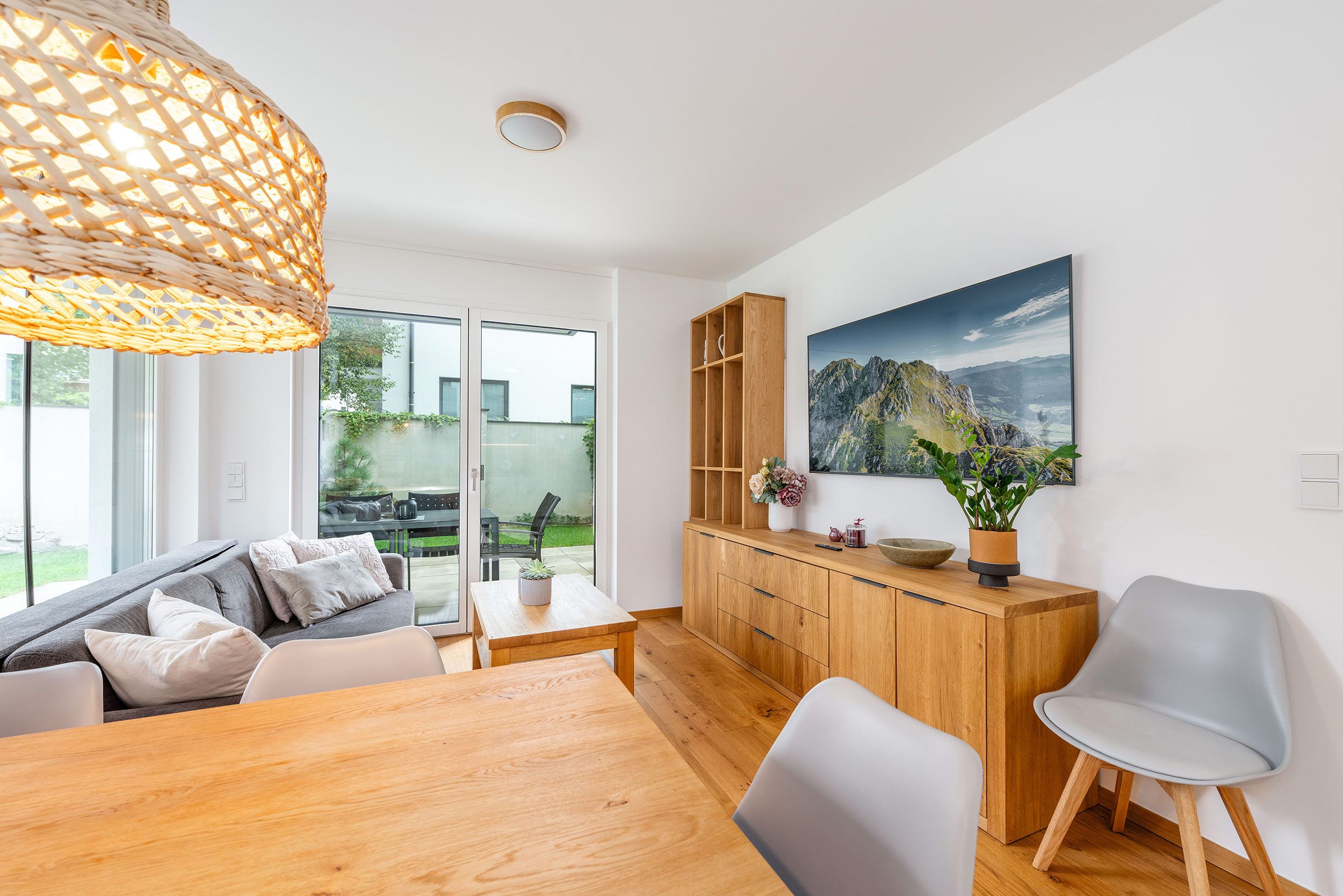 Una sala de estar moderna con un sofá, una mesa de comedor y un mueble de madera.
