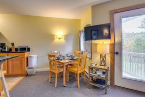 Une cuisine de taille réduite comprenant une table à manger, des chaises, un four à micro-ondes et un réfrigérateur.