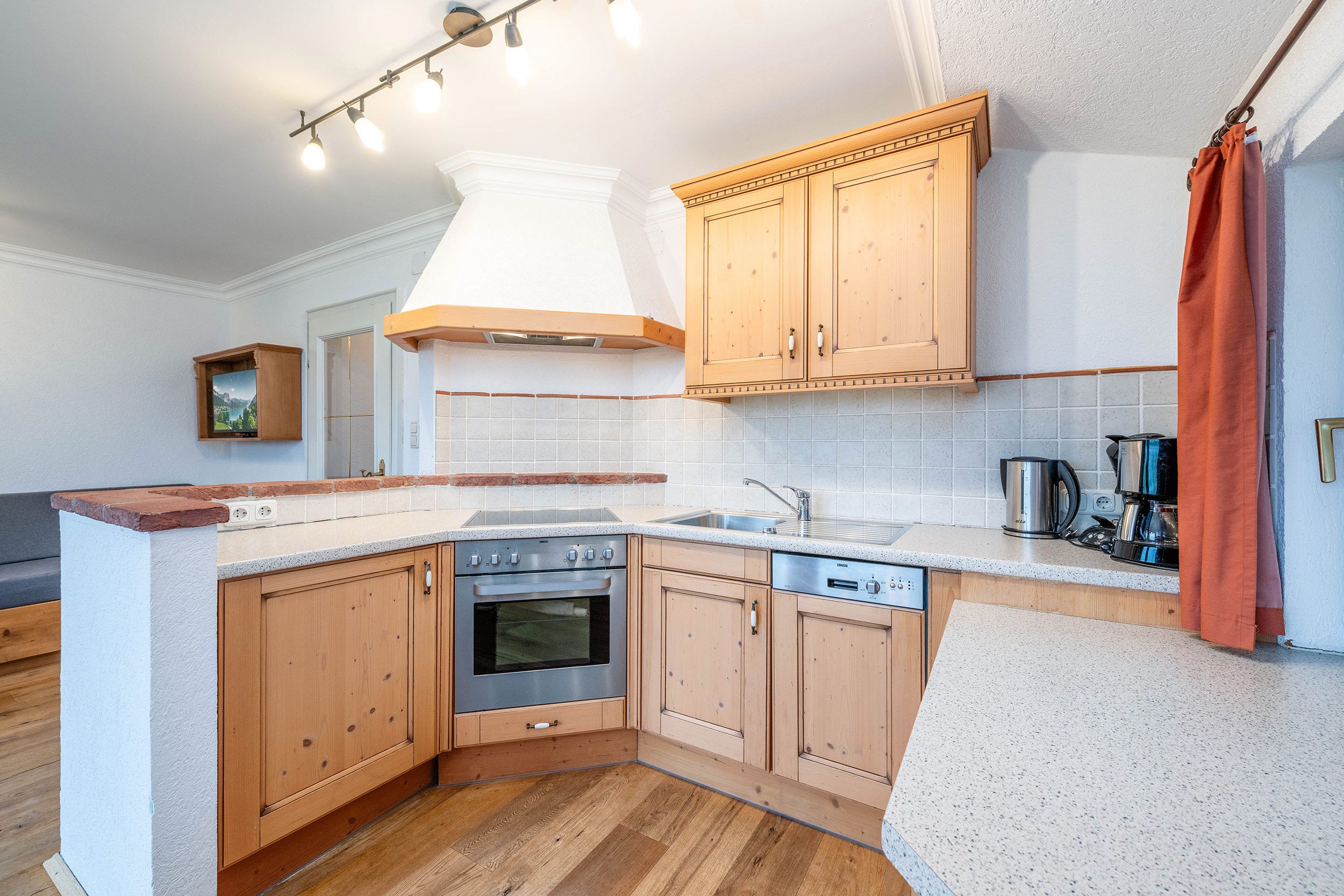 A kitchen with wooden cabinets, a built-in oven, a dishwasher, and a countertop.