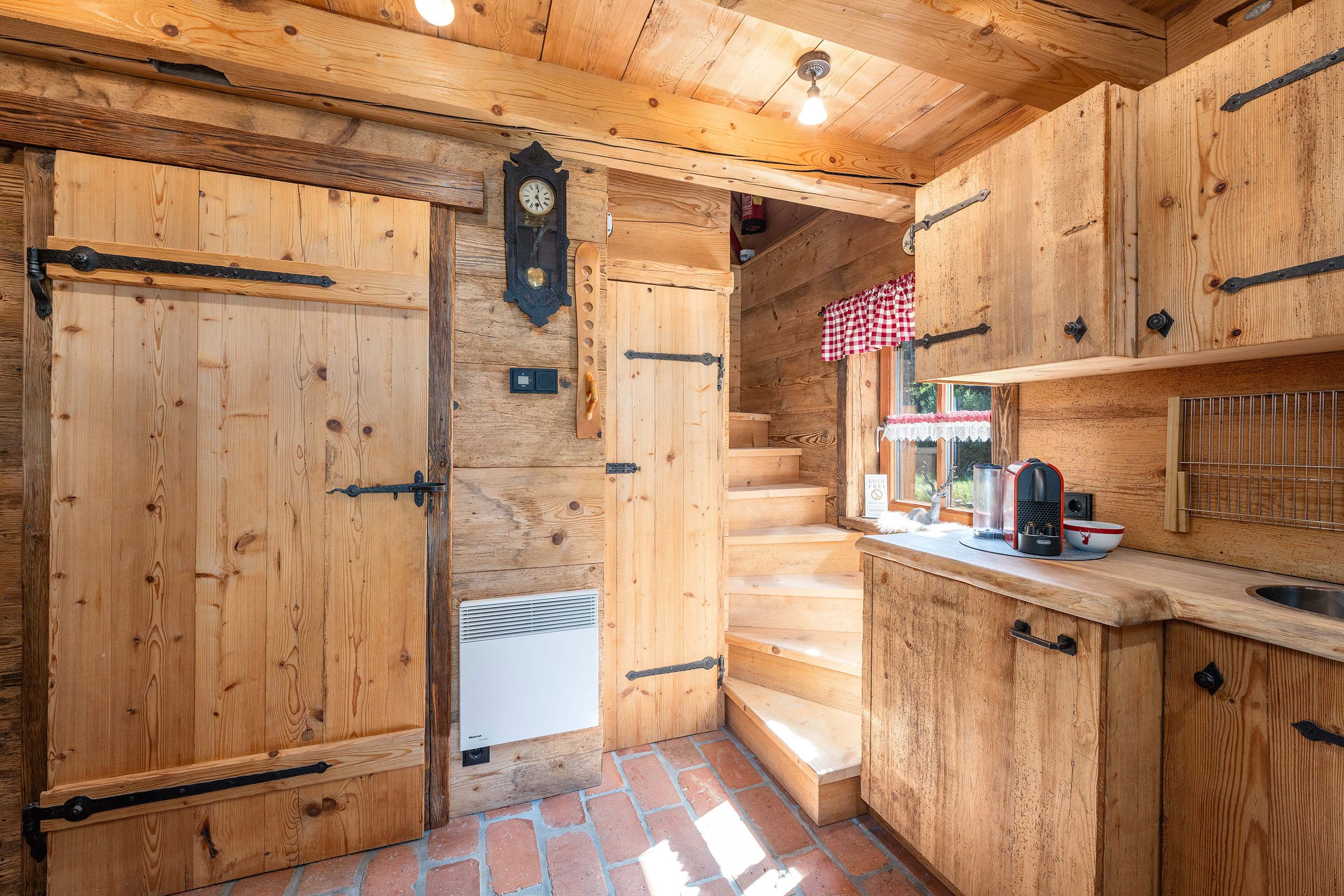 Un intérieur en bois avec un escalier menant à une cuisine.