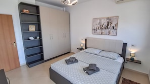 Une chambre à coucher avec un lit, une armoire, un tableau et des lampes de chevet.